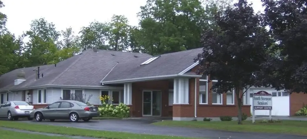 The single-storey brick and white-sided building at 34 Memorial Square, Ingleside, with trees and a sign out front