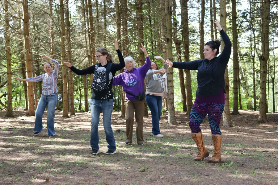 Angélique leading a belly dance class among the pines at the Greenwood Sanctuary Harvest Fair