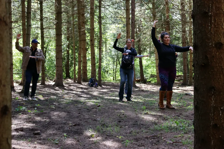 The class dancing together under the pine trees