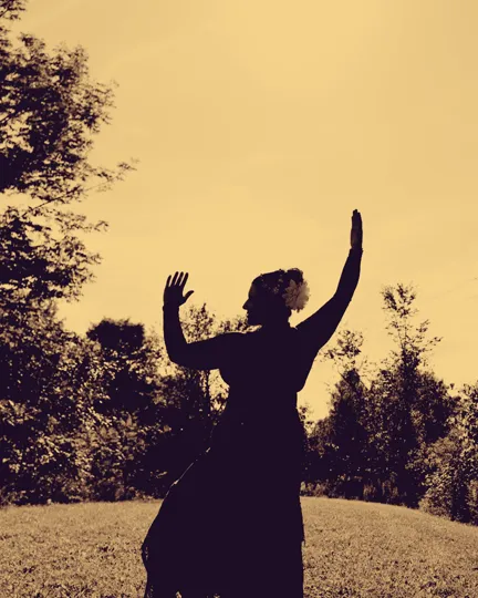 Angélique’s silhouette against a golden sky, arms raised